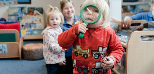 Child looking through large magnifying glass